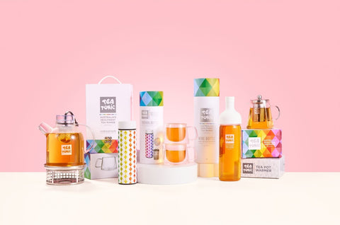 Collection of tea pots and related products on a pink background