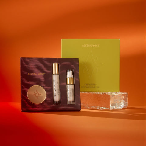 Skincare product set with two bottles and a box on an orange background